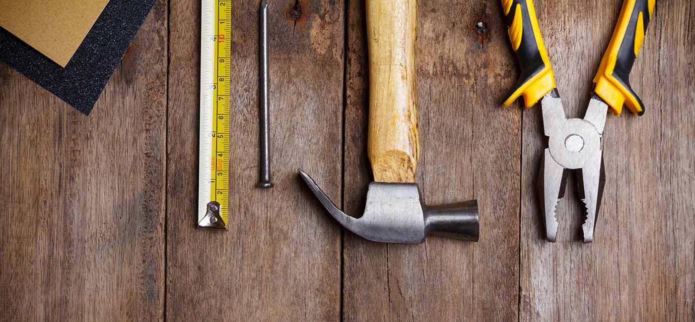 Tape measure, hammer, and pliers on a table!''